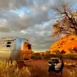 Anne sits in a camp chair outside the Airstream at sunset in Canyonlands National Park