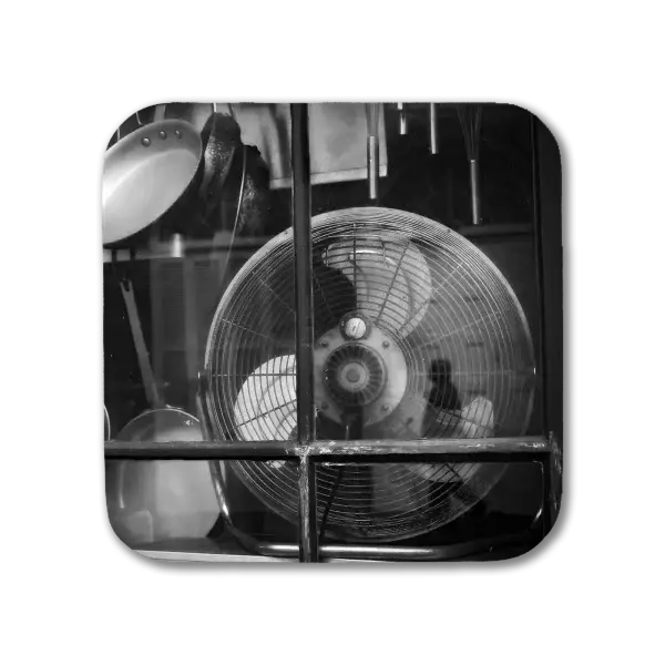 Coaster with a B&W Image in New Orleans' French Quarter of kitchen utensils reflecting the image of a pedestrian
