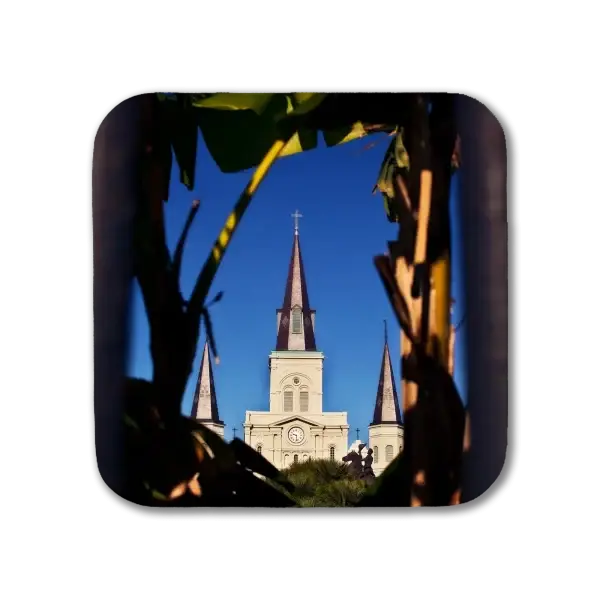 A coaster featuring a New Orleans picture of St Louis Cathedral as shot through palm leaves and the fence surrounding Jackson Square