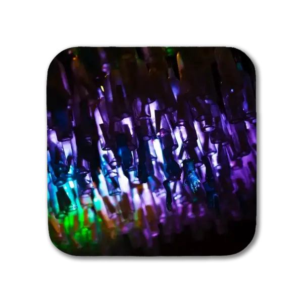 A coaster featuring a New Orleans scene of a colorful sculpture of bottles mounted upside down and backlit