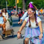 A costumed female rider bikes in the Tour de Fat