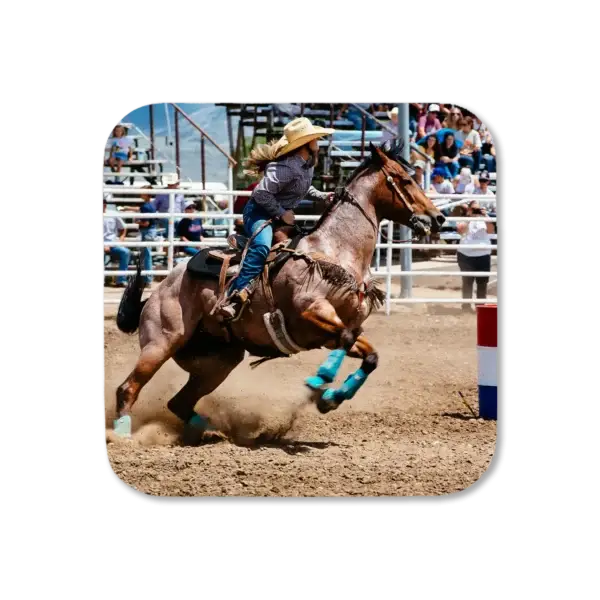 A cowgirl rounds a barrel with expert precision during a rodeo event