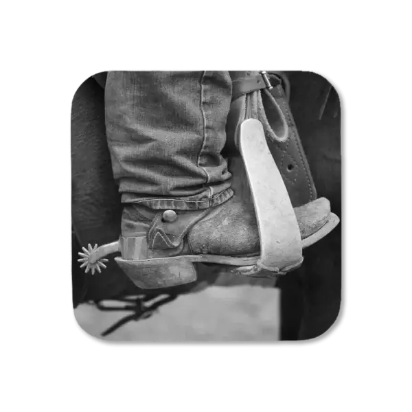 Close-up of a cowboy boot with spurs, in a saddle, artwork for a coaster