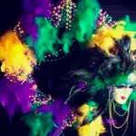 A Mardi Gras wreath of festive colors with feathers and beads, and a mask.