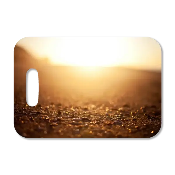Premium luggage tag featuring a sunrise on the pebbled beach at a Mexican resort.