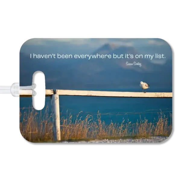 New Zealand Sea Bird Sits on Fence Luggage Tag Premium luggage tag featuring a New Zealand seagull standing along a fence with the ocean in the background. Supimposed quote says I haven't been everywhere but it's on my list, by Susan Sontag.